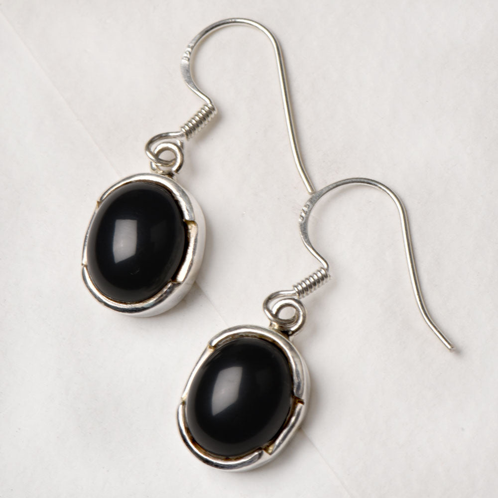 The Oval Dangle Earrings displayed with its subtle quiet design and gemstone stone