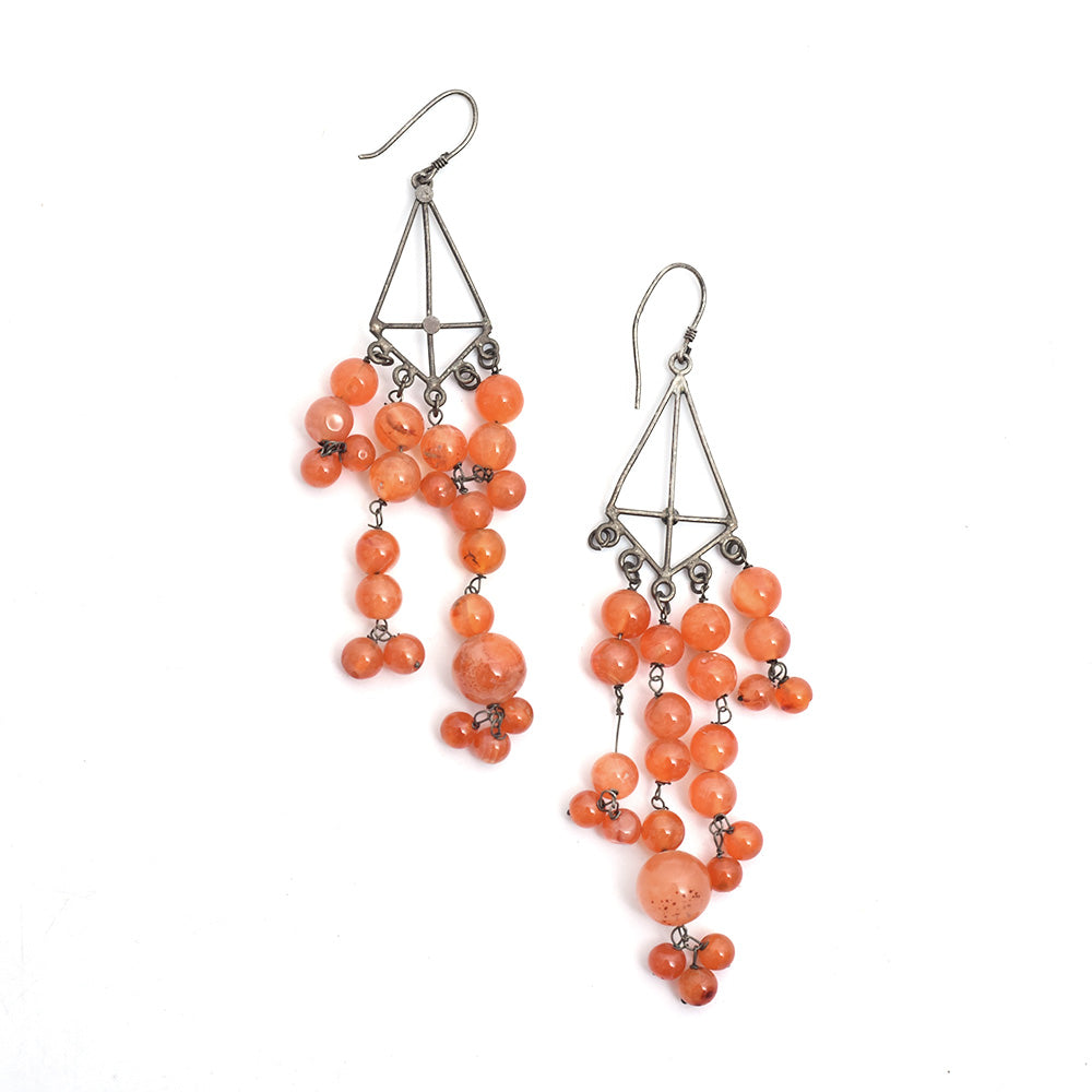 Pair of carnelian dangle earrings laid flat, displaying handcrafted craftsmanship in 92.5 Sterling Silver.