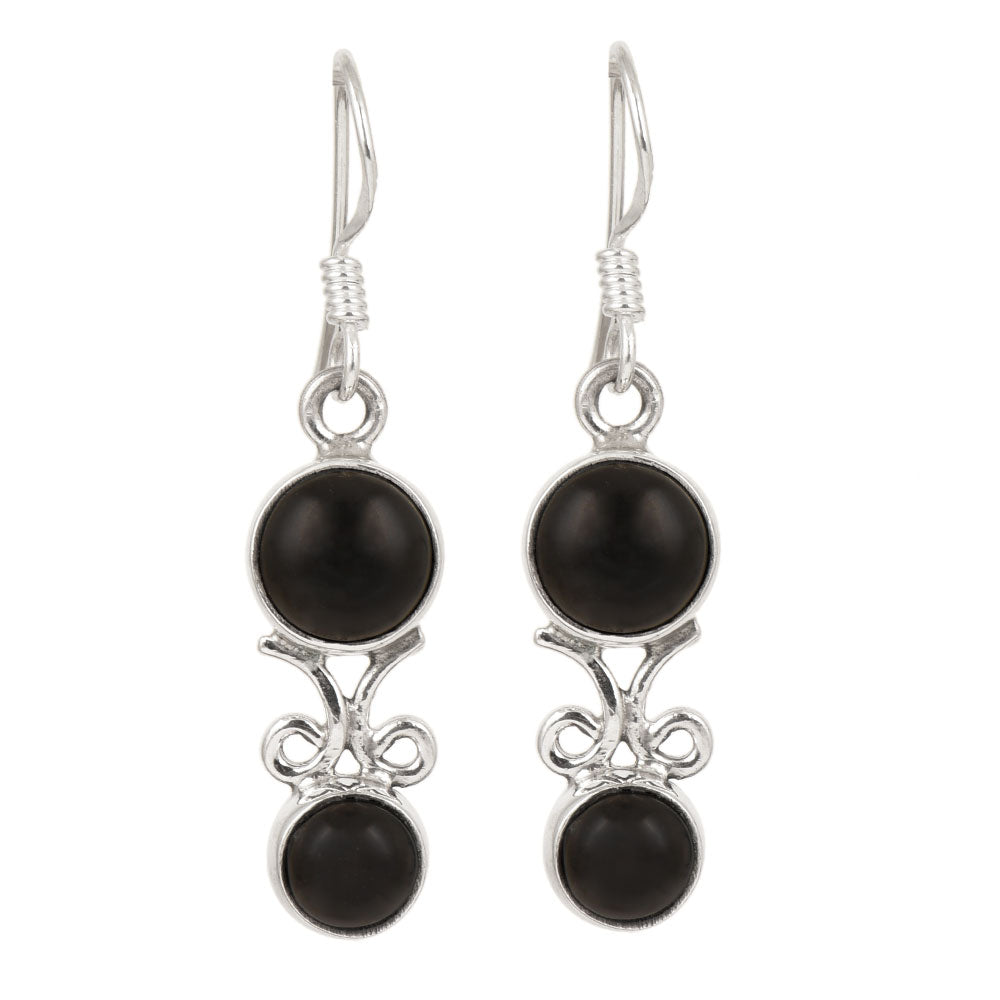 Side angle showing black onyx drop earrings with black , silver tones.