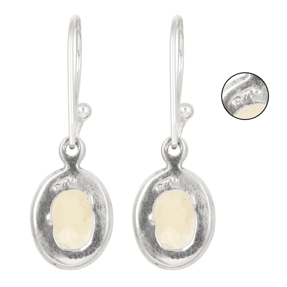 Side angle showing topaz dangle earrings with silver tones.