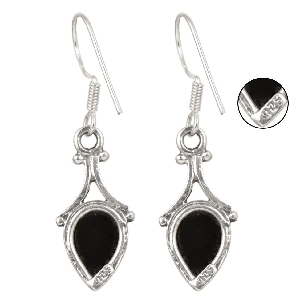 Side angle showing onyx teardrop drop earrings with silver tones.