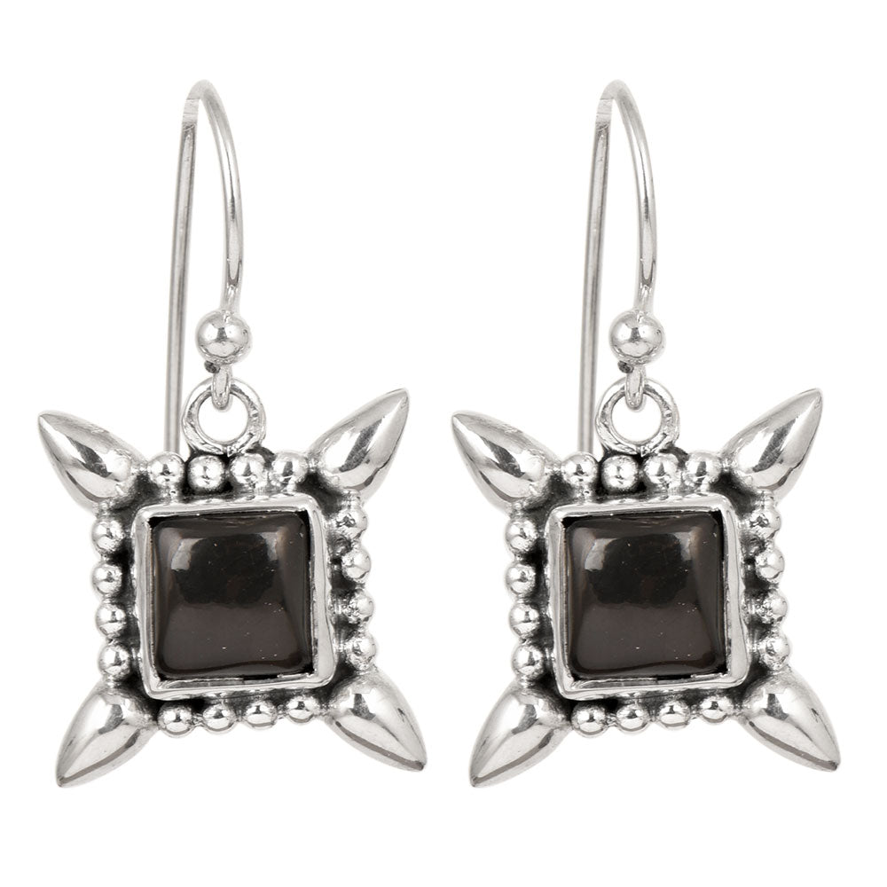 Side angle showing square dangle earrings with black , silver tones.