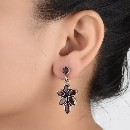Pair of Garnet Floral Dangle Earrings displayed on a neutral background for a clear view.