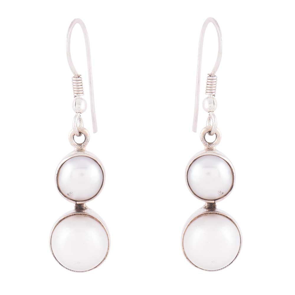 Moti Pearl dangle earrings resting on fabric, showing pearl and subtle handwork.