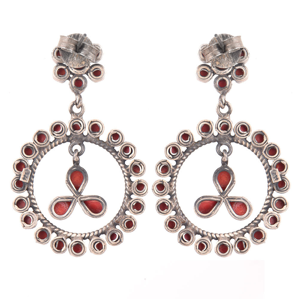 Close-up view of coral stone dangle earrings set in oxidised silver