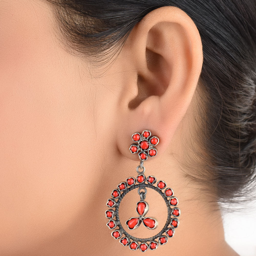 Coral round dangle earrings in 925 sterling silver worn close to the ear