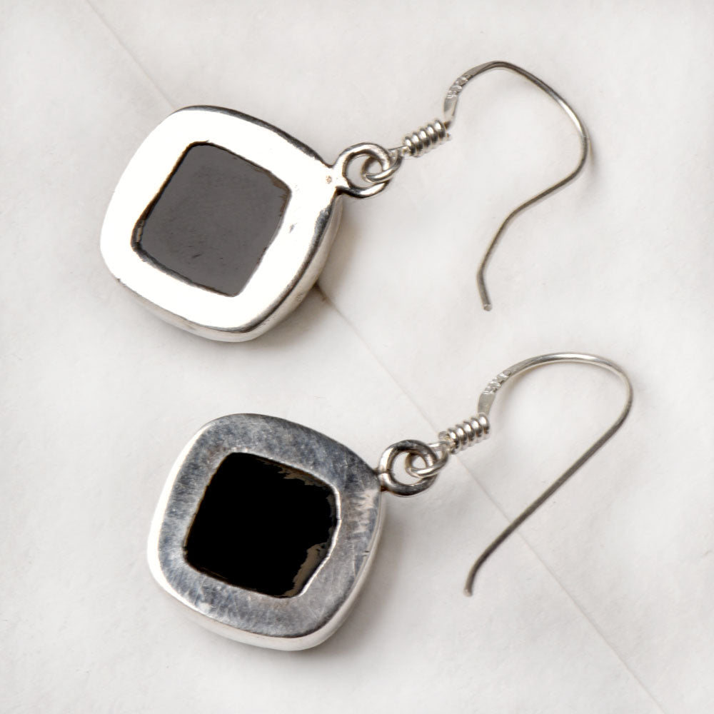 Side view of the artisan made Black Onyx Square Drop Earrings revealing the texture and light play