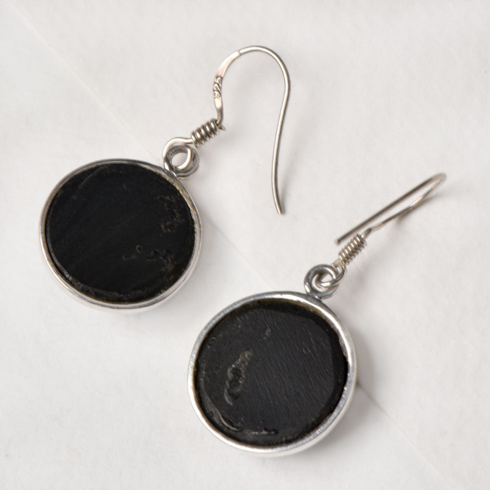 Side view of the artisan made Onyx Round Drop Earrings revealing the texture and light play