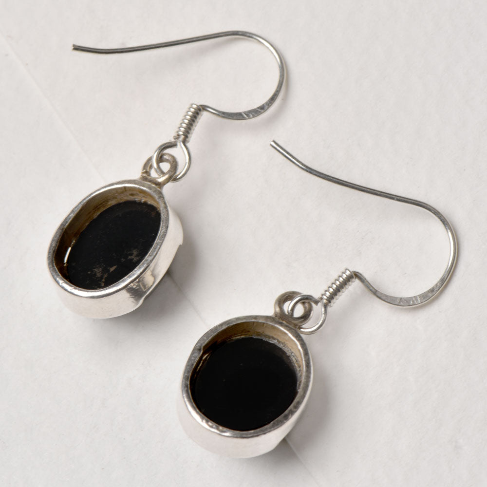 Side view of the artisan made Oval Dangle Earrings revealing the texture and light play