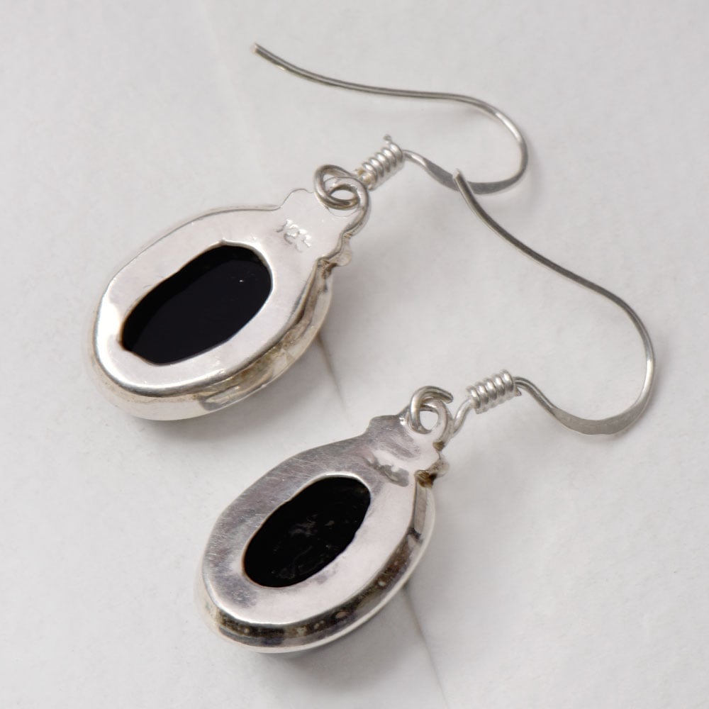 Side view of the artisan made Black Onyx Oval Earrings revealing the texture and light play