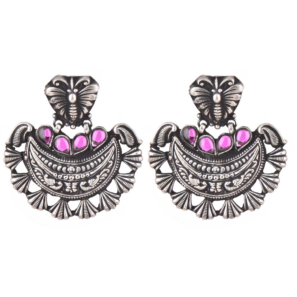 Side profile showing silver work on the stud earrings