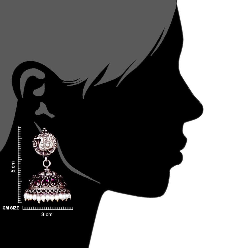 Artisan hands crafting the peacock earrings