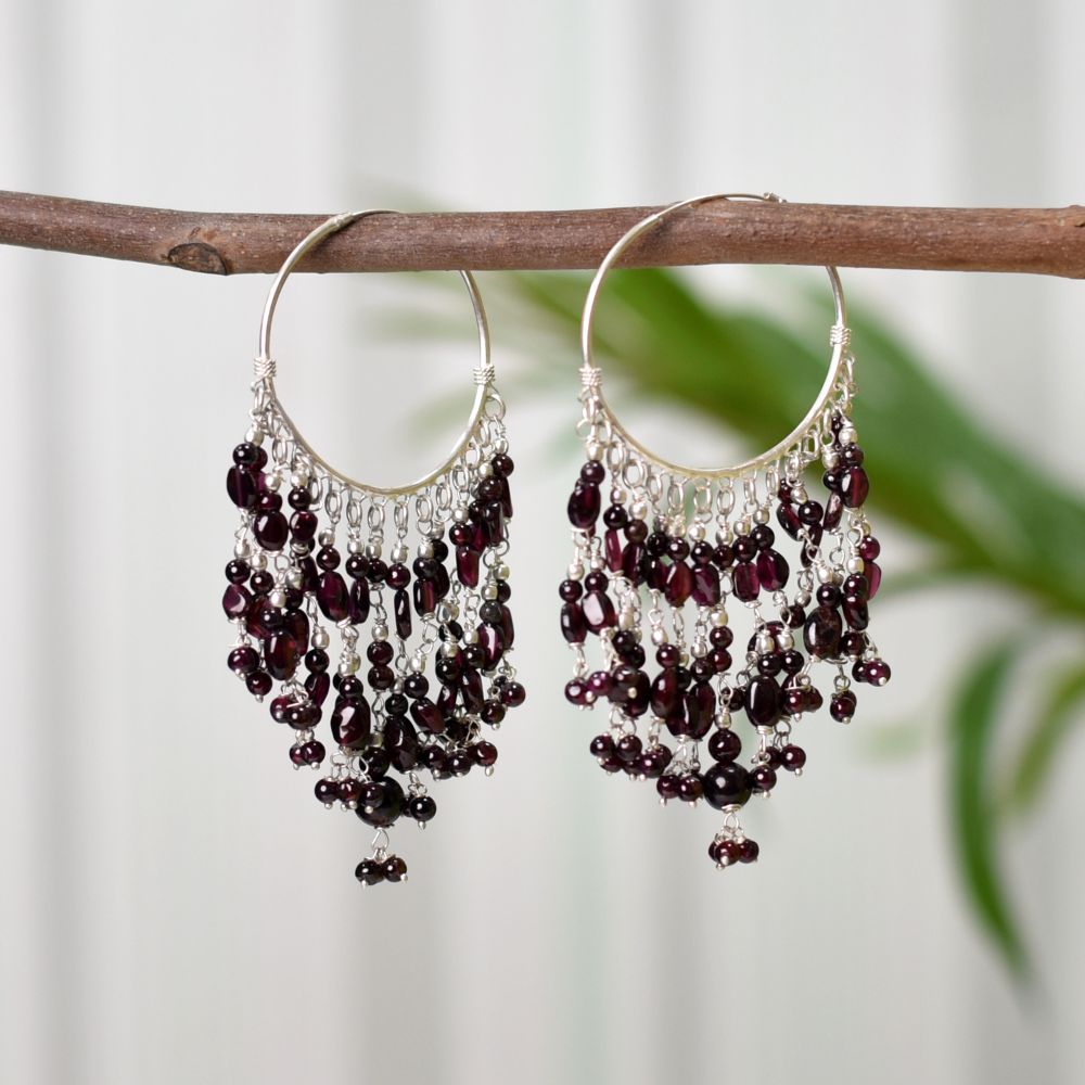 Pair of garnet hoop earrings displayed flat showing size and proportion.