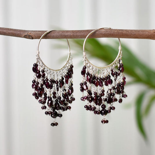 Pair of garnet hoop earrings displayed flat showing size and proportion.
