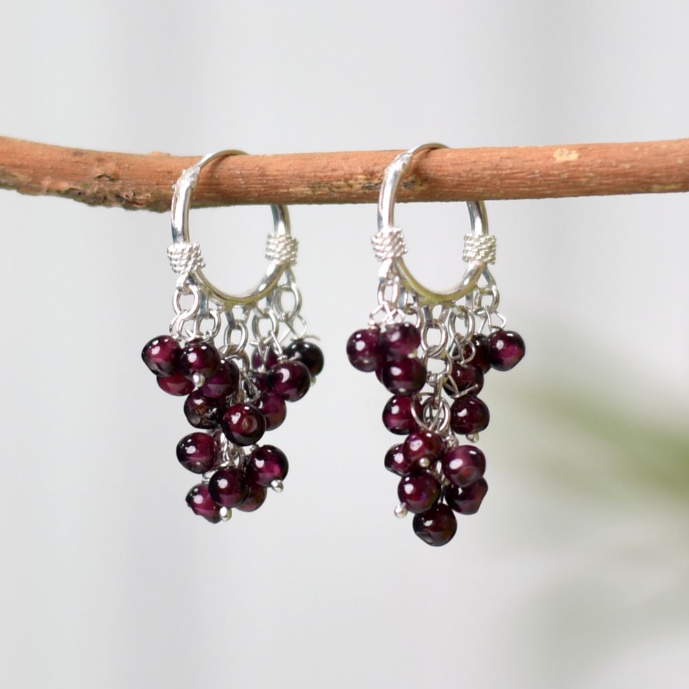 Pair of Garnet Hoop Earrings on a display stand, crafted from 92.5 Sterling Silver.