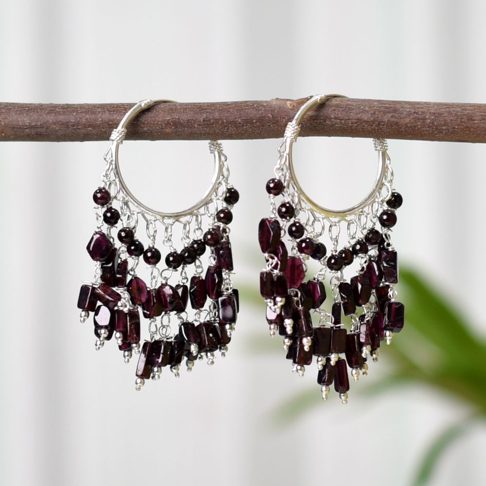 Pair of Garnet Earrings on a display stand, crafted from 92.5 Sterling Silver.